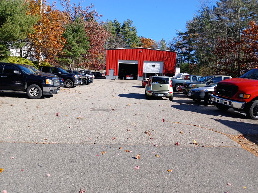 Modern auto body shop bay with a car being serviced